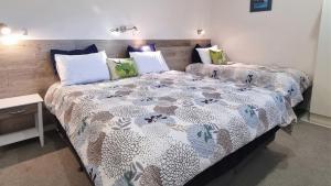 um quarto com 2 camas e almofadas em Admirals View Lodge em Paihia