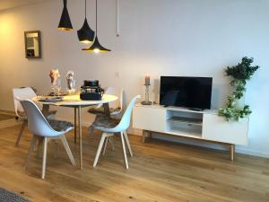 a dining room with a table and a tv at Ferienwohnung nähe Flumserberg Ski Wandergebiet in Filzbach