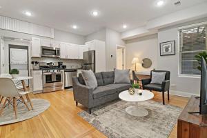 ein Wohnzimmer mit einem Sofa und einem Tisch in der Unterkunft 1BR Deluxe Apartment near Shops & Cafés - Ashland 1F in Chicago