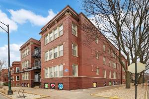 a large red brick building on a city street at 1BR Deluxe Apartment near Shops & Cafés - Ashland 1F in Chicago