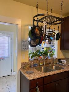 a kitchen sink with pots and pans hanging above it at Spacious Private Los Angeles Bedroom with AC & WIFI & Private Fridge near USC the Coliseum Exposition Park BMO Stadium University of Southern California in Los Angeles