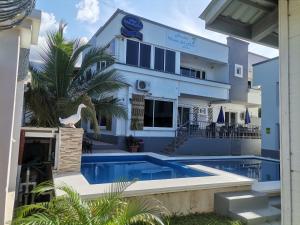 a house with a swimming pool in front of it at Hostal Vista del Mar in Trujillo