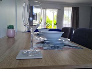 un tavolo con un bicchiere di vino sopra di Kings Court Motel a Whanganui