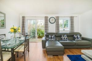 a living room with a couch and a glass table at Beautiful 3 Bed House with Amazing Views in Dartford, Kent in Kent