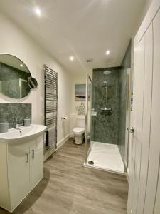 a bathroom with a shower and a sink and a toilet at Cosy Cottage in Stirling