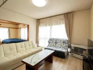 salon z kanapą i stołem w obiekcie LY INN CHITOSEAIPORT - Vacation STAY 94792 w mieście Chitose