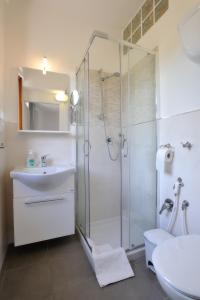 uma casa de banho com um chuveiro, um lavatório e um WC. em Casarimidia em Perugia