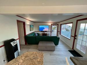 ein Wohnzimmer mit einem grünen Sofa und einem TV in der Unterkunft Catalina Two Bedroom View Home in Avalon