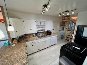 a kitchen with white cabinets and a black refrigerator at Catalina Two Bedroom View Home in Avalon