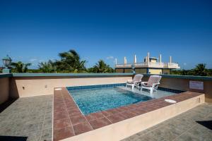 a swimming pool with two chairs and a house at El Gran Castillo De Arena in San Pedro