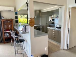 a kitchen with a counter and stools in it at Queenstown Lake Panorama in Queenstown