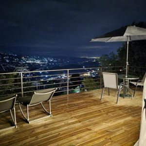 una terraza con mesa, sillas y sombrilla en Solaris Glamping Exclusive en Tena