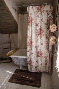 łazienka z zasłoną prysznicową i wanną w obiekcie Grist Mill Inn w mieście Monticello