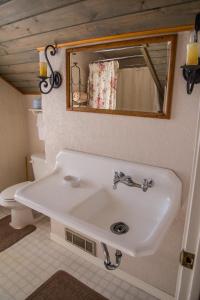 W łazience znajduje się umywalka, lustro i toaleta. w obiekcie Grist Mill Inn w mieście Monticello