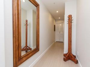 a hallway with a large mirror and a wooden frame at Sparkling Gem, Brand New Condo In The Heart Of The City in Victoria