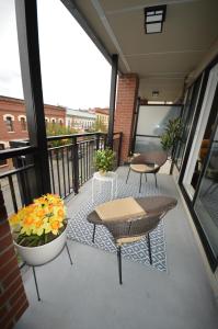 a balcony with a table and chairs and flowers at Chic 1Br Steps From Chinatown And Harbour in Victoria