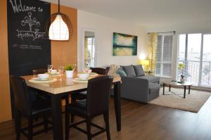 a dining room and living room with a table and chairs at Chic 1Br Steps From Chinatown And Harbour in Victoria +8 photos