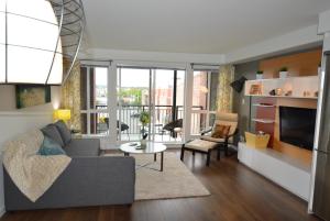 a living room with a couch and a table at Chic 1Br Steps From Chinatown And Harbour in Victoria
