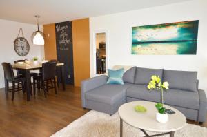 a living room with a couch and a table at Chic 1Br Steps From Chinatown And Harbour in Victoria