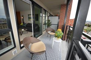 a balcony with two chairs and a table at Chic 1Br Steps From Chinatown And Harbour in Victoria
