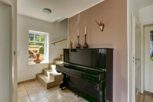 a living room with a piano and a staircase at Villa Meisen in Medebach