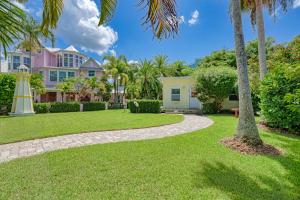 a house with palm trees and a walkway at AMI Lighthouse Cottage-One Minute Walk To The Beach-Keyless Locks in Bradenton Beach