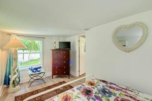 a bedroom with a bed and a mirror on the wall at AMI Lighthouse Cottage-One Minute Walk To The Beach-Keyless Locks in Bradenton Beach