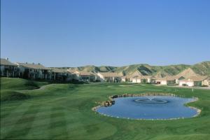 a view of a golf course with a pond at Paradise Canyon Golf Resort, Signature Walkout Condo 380 in Lethbridge