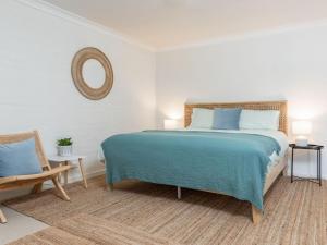 1 dormitorio con 1 cama grande y 1 silla en Ponderosa, en Blueys Beach