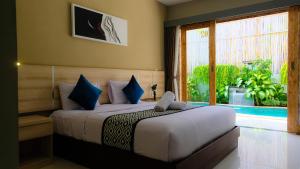 a bedroom with a bed and a large window at Rusty Seminyak in Seminyak