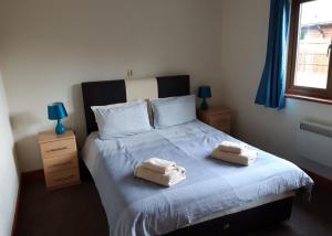 um quarto com uma cama com duas toalhas em Heartsease Lodges em Llanbister