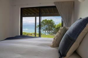 a bedroom with a large bed with a large window at Fuller Holidays - Jane's on Wategos Unit 2, 37 Marine Pde-2 Bed Villa in Byron Bay