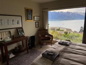 a bedroom with a large window with a view of the water at Queenstown Lake Panorama in Queenstown