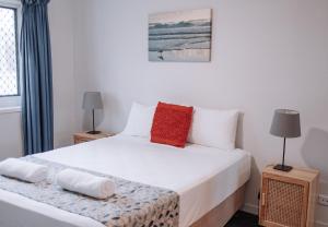 Un dormitorio con una cama blanca y dos lámparas. en Surfers Horizons, en Gold Coast