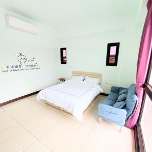1 dormitorio con 1 cama y 1 sofá azul en Xian Jing B&B en Jiaoxi