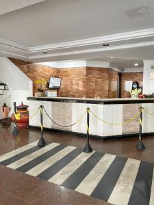 a lobby with a bar with a yellow and black striped rug at Flat vista mar com estacionamento incluído in Salvador