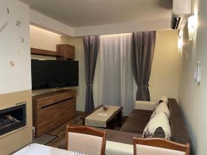 a living room with a couch and a flat screen tv at Grand Bansko 1 Family apartment B206 in Bansko