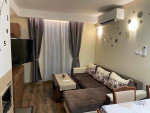 a living room with a couch and a tv at Grand Bansko 1 Family apartment B206 in Bansko