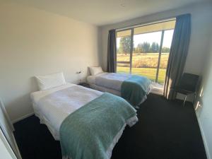 a hotel room with two beds and a large window at Macaulay House in Lake Tekapo