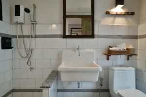 La salle de bains est pourvue d'un lavabo, de toilettes et d'un miroir. dans l'établissement Velawarin Hotel, à Ubon Ratchathani