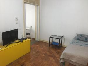 1 dormitorio con TV en un tocador con cama en Apartamento em Ipanema 1 quarto, prox ao Arpoador - Disponível para o feriado de Corpus Christi, en Río de Janeiro