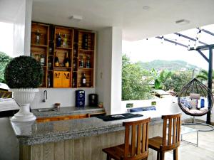 a kitchen with a bar with two chairs and a window at Centro Vacacional "El Pro" in Puerto López