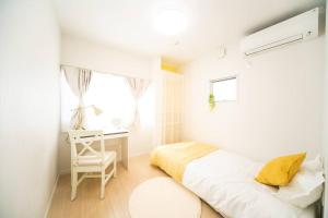 Habitación blanca con cama y escritorio en Shizukinosato TSUKI Terrace 531, en Awaji