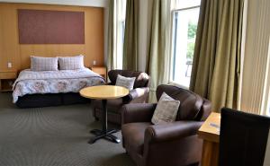 Habitación de hotel con cama, mesa y sillas en Brydone Hotel Oamaru, en Oamaru