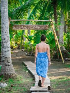 a woman walking down a wooden path in a blue dress at Entremares in Tonalá