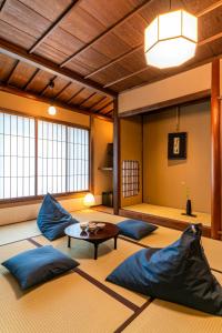 Habitación con almohadas azules y mesa. en Saik, en Kanazawa