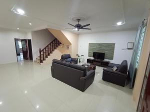 een woonkamer met banken en een flatscreen-tv bij Sunny Homestay Kuching - LANDED 14 PAX in Kuching