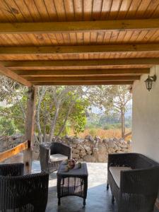 a patio with chairs and a table and a wooden ceiling at Las Cabañas de Incahuasi in Lunahuaná