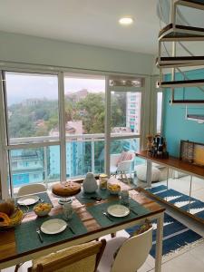 a dining room with a table and a large window at Apartamento Cobertura Porto Real Suites in Mangaratiba +41 photos