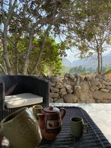 stół z dwoma kubkami i dzbanem do herbaty w obiekcie Las Cabañas de Incahuasi w mieście Lunahuaná